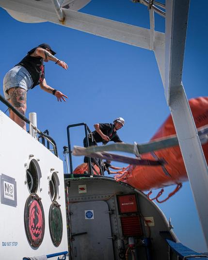 crew throws life saving equipment from board into sea
