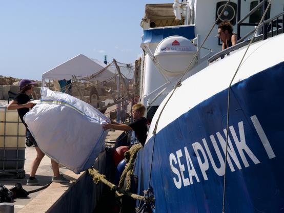 Crew members sort and stow life jackes on Sea Punk I