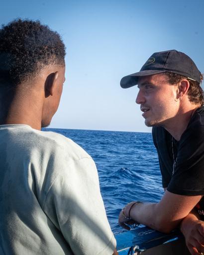 survivor and crew exchanging while looking at the sea