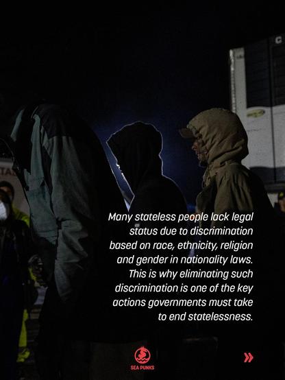 A dark night scene of people in hoods and jackets standing beside a truck, dimly lit. White text: "Many stateless people lack legal status due to discrimination based on race, ethnicity, religion and gender in nationality laws. This is why eliminating such discrimination is one of the key actions governments must take to end statelessness."